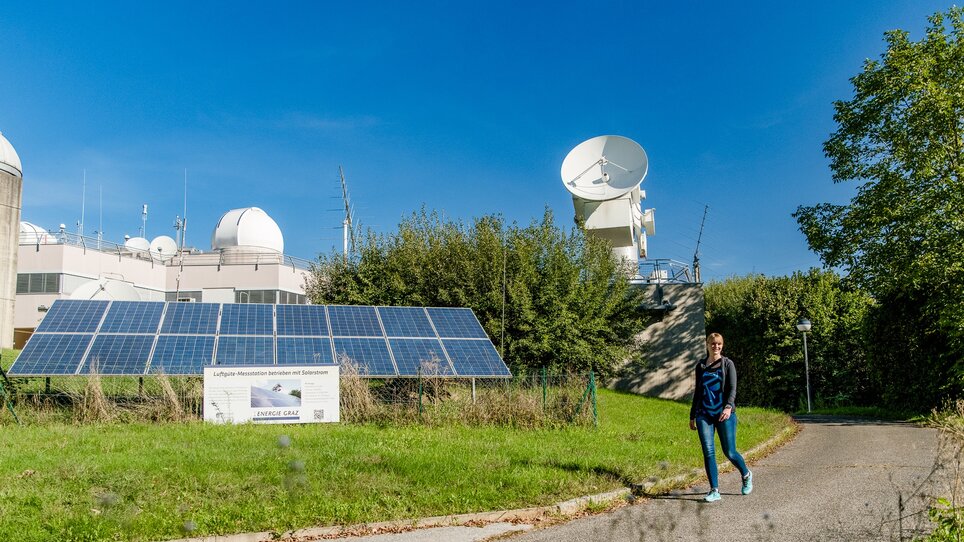 A woman walks past the Lustbühel observatory in Graz, with satellite dishes in the background. | © Graz Tourismus