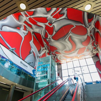 Moderne Treppe mit künstlerischem Deckendesign im Hauptbahnhof Graz. | © Graz Tourismus - Harry Schiffer