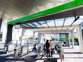 Ingresso moderno alla stazione ferroviaria di Graz con distributori automatici e passeggeri. | © Graz Tourismus - Harry Schiffer