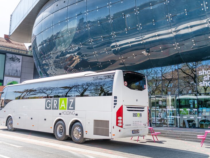 Ein Bus von Graz Holding steht vor dem Kunsthaus Graz in der Stadt Graz. | © achtzigzehn - Hinterleitner