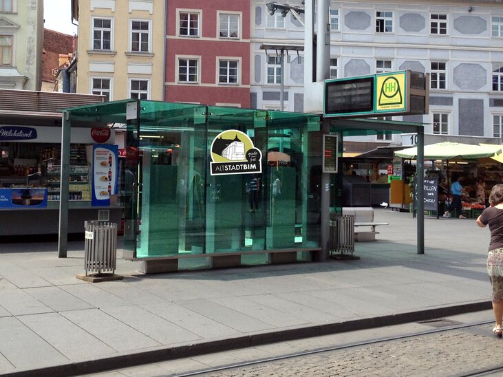 Modern glass bus stop with the inscription 'ALTSTADTBIM' in Graz. | © Holding Graz Linien