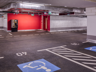 Vista di un parcheggio con posti per disabili e un bancomat. | © Intercity Hotel Graz