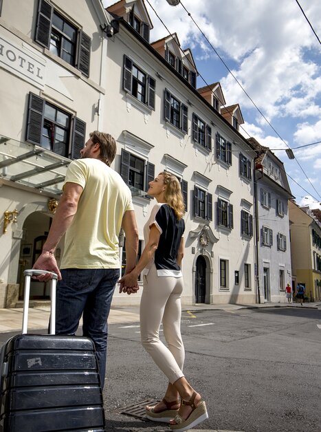 Pärchen mit Koffer vor dem Schlossberghotel in Graz | © Graz Tourismus - Tom Lamm