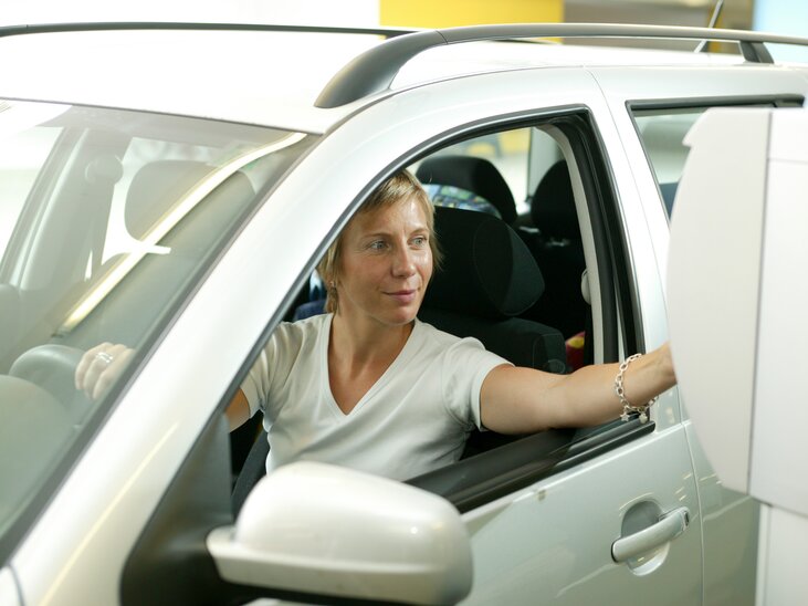 Eine Frau im Auto bei einem Parkautomaten in einem Parkhaus in Graz | © Graz Tourismus - Harry Schiffer