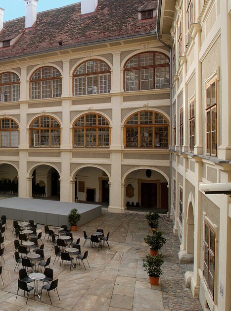 Innenhof Lesliehof Joanneumsviertel: Gemütlicher Innenhof mit Tischen und Stühlen für Gäste. | © Universalmuseum Joanneum