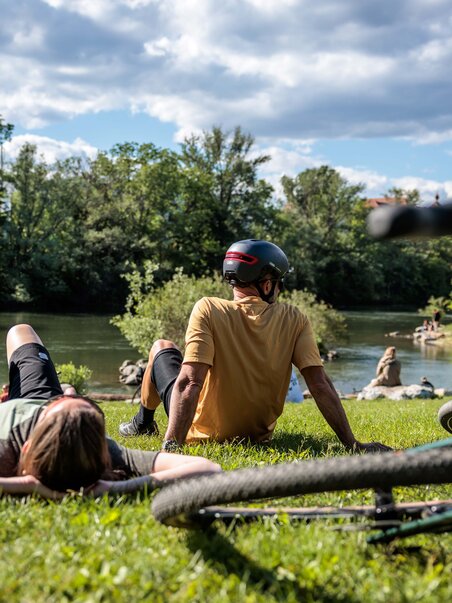 Due persone si rilassano sulla riva di un corpo d'acqua. | © Region Graz - Erwin Haiden