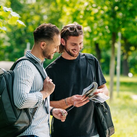 Two men in Augarten Graz looking at a map. | © Graz Tourismus - Mias Photoart