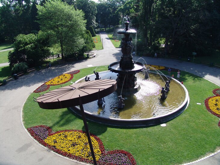 Un bel parco cittadino con una fontana e aiuole fiorite. | © Graz Tourismus - ZeppCam