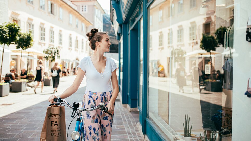 Una donna a Graz guarda in una vetrina mentre tiene una busta per la spesa. | © Graz Tourismus