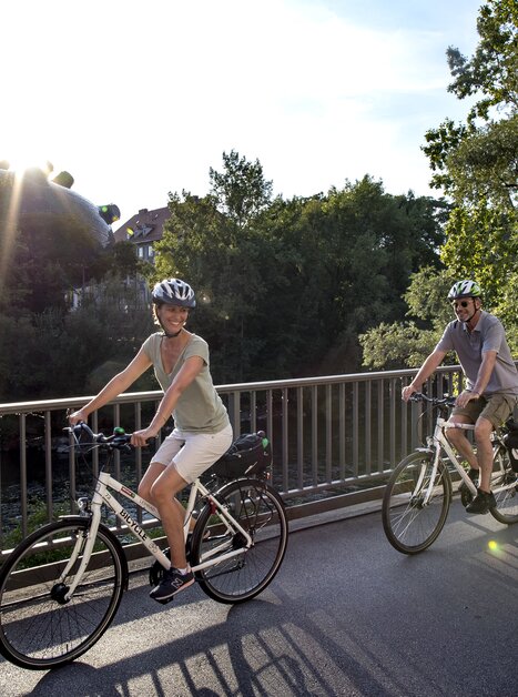 Verschiedene Fahrradfahrer genießen eine Radtour in Graz entlang der Mur. | © Graz Tourismus - Tom Lamm