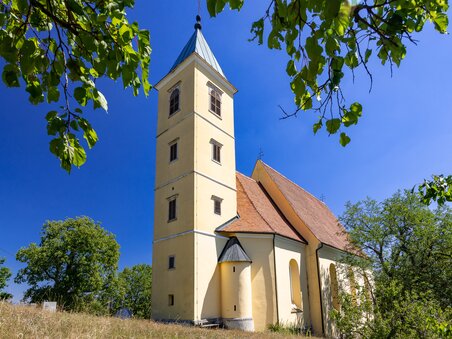 Eine Kirche mit Turm vor blauem Himmel und Bäumen. | © Graz Tourismus - Harry Schiffer