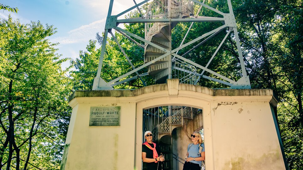 Zwei Frauen stehen vor der Rudolfswarte - im Rahmen der Gipfelwanderung im Grazer Westen. | © Graz Tourismus - Mias Photoart