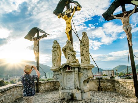 Besucher fotografiert Kreuzigungsszenen am Grazer Kalvarienberg mit Stadt im Hintergrund. | © Graz Tourismus - Mias Photoart-8