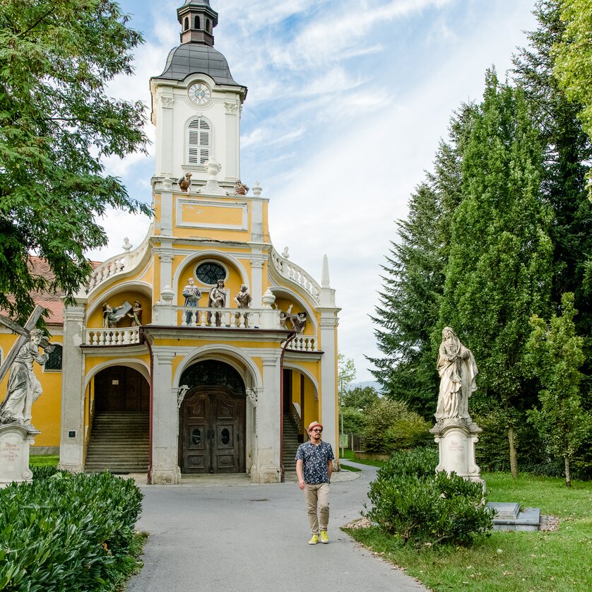 Kalvarienbergkirche in Graz | © Graz Tourismus - Mias Photoart-11 Man in front of the Kalvarienbergkirche in Graz with statues in the garden. | © Graz Tourismus - Mias Photoart-11