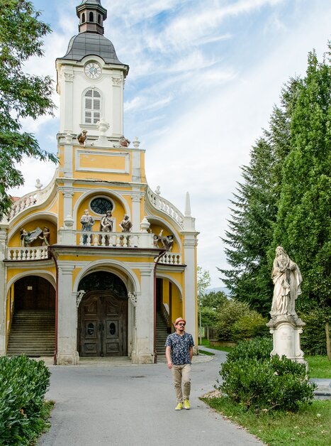 Uomo davanti alla Kalvarienbergkirche a Graz con statue nel giardino. | © Graz Tourismus - Mias Photoart-11