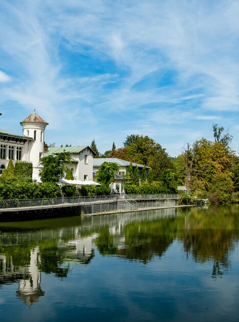 Un edificio pittoresco sull’Hilmteich di Graz si riflette nell’acqua. | © Graz Tourismus - Mias Photoart