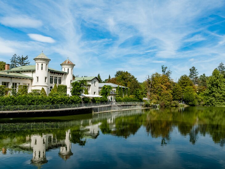 Un edificio pittoresco sull’Hilmteich di Graz si riflette nell’acqua. | © Graz Tourismus - Mias Photoart