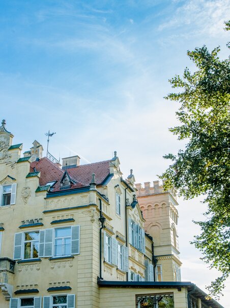 Schloss Lustbühel con torri e alberi sotto un cielo sereno a Graz. | © Graz Tourismus - Mias Photoart
