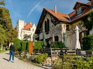Scena idilliaca con una Buschenschank e Schloss Lustbühel sullo sfondo. | © Graz Tourismus - Mias Photoart