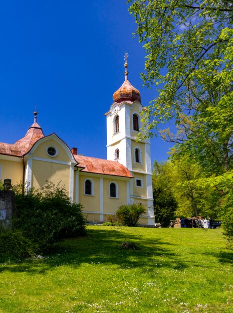 Eine Kirche umgeben von Bäumen und Gras an einem sonnigen Tag. | © Graz Tourismus - Harry Schiffer