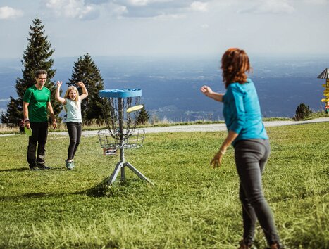 Familie spielt Disc Golf am Schöckl mit Blick auf die Berge. | © Holding Graz - Lex Karelly