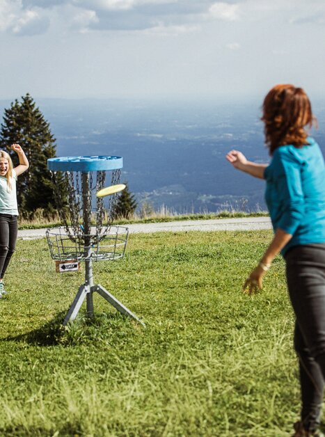 Family playing disc golf at Schöckl with mountain view. | © Holding Graz - Lex Karelly