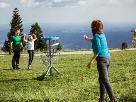 Family playing disc golf at Schöckl with mountain view. | © Holding Graz - Lex Karelly