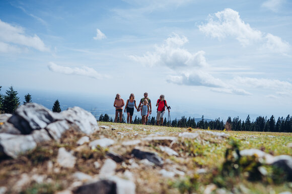 Fünf Personen wandern auf dem Schöckl mit Aussicht auf die Landschaft. | © Lex Karelly