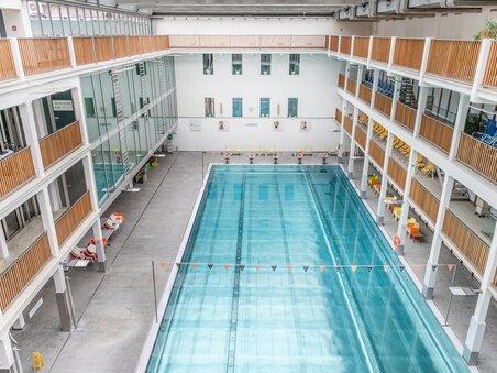 Interior view of the Bad zur Sonne pool in Graz featuring the water basin and seatings. The environment is bright and modern. | © Holding Graz - achtzigzehn