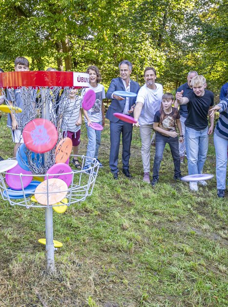 Gruppe von Jugendlichen und Erwachsenen spielt Discgolf in der Natur. | © Stadt Graz - Foto Fischer