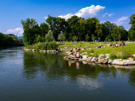 Entspannung am Mur-Ufer in Graz mit Badegästen und Grünflächen. | © Harry Schiffer