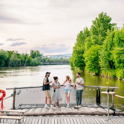 Gruppe von Freunden genießt Zeit am Fluss in Graz, umgeben von Bäumen. | © Graz Tourismus - Mias Photoart