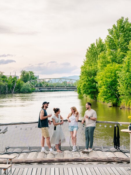 Gruppe von Freunden genießt Zeit am Fluss in Graz, umgeben von Bäumen. | © Graz Tourismus - Mias Photoart