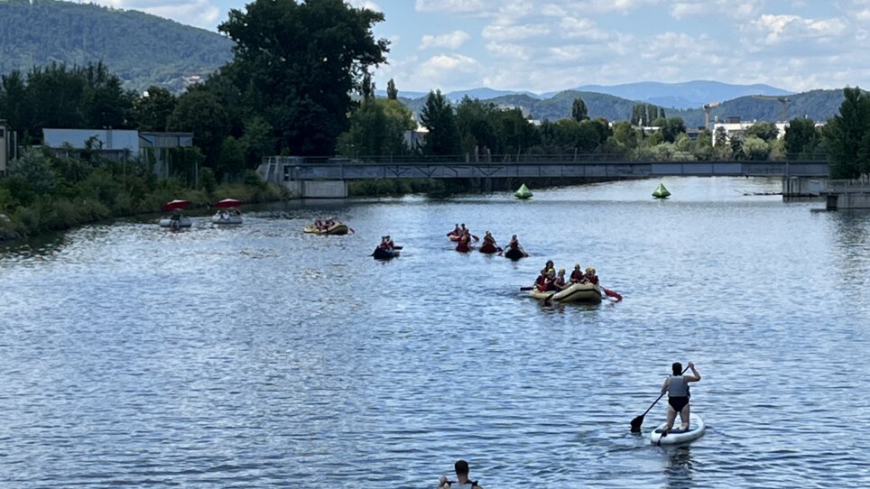 Persone che remano sulla Mur a Graz, godendo del bel tempo. | © Die Flößerei