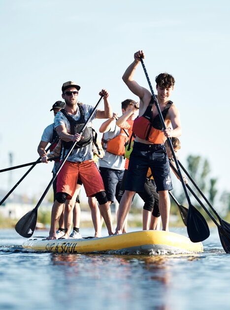 Group of people paddling on a large SUP in the water. | © Stadtstrand Graz - Stefan Leitner