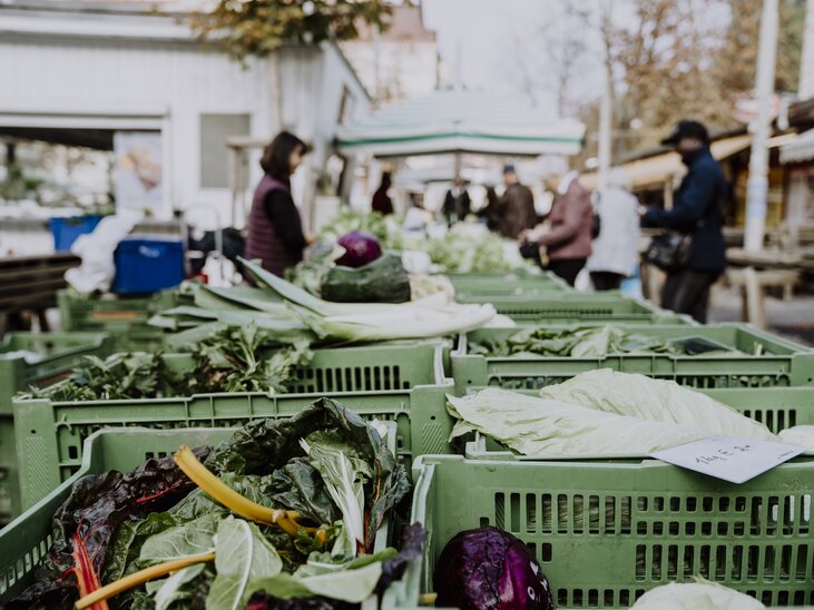 Gemüse steht auf einem Markt, mit Besuchern im Hintergrund. | © Nina Söntgerath - Reisehappen