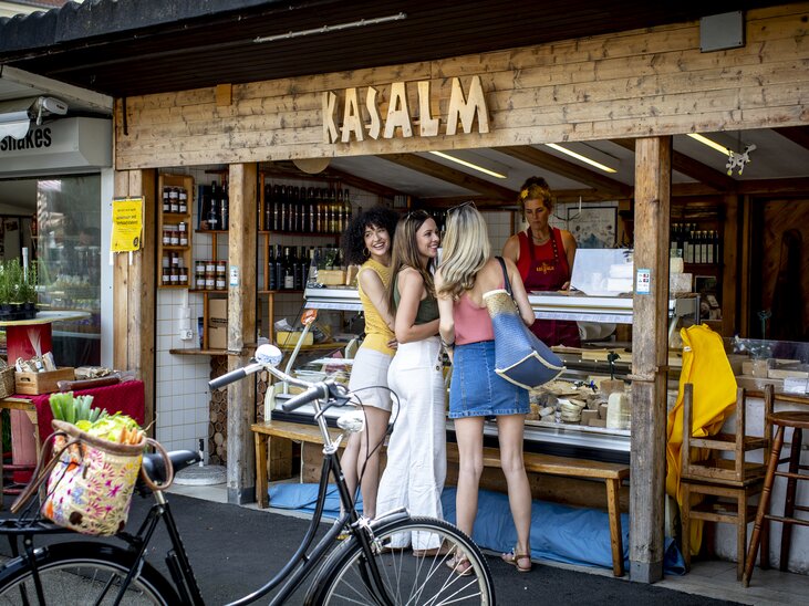 Tre donne davanti a una bancarella al mercato di Graz. | © Graz Tourismus - Tom Lamm