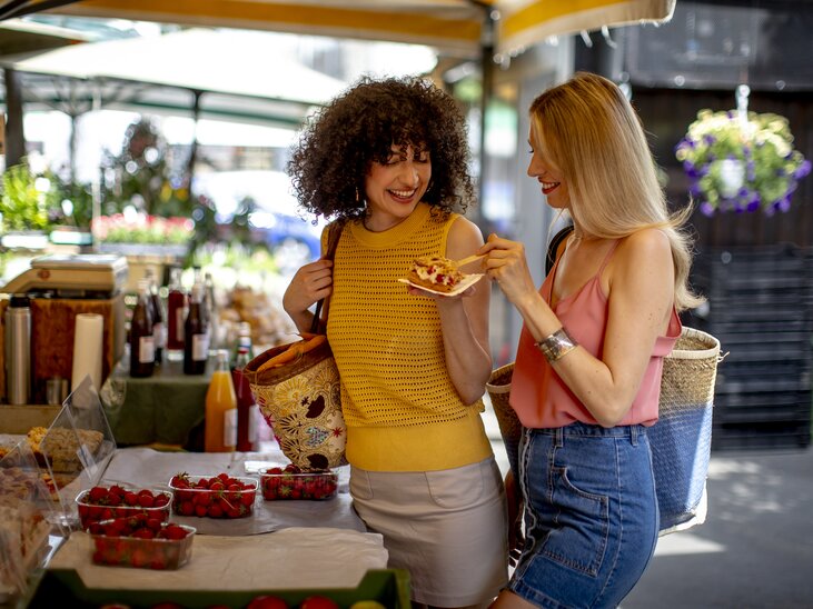 Zwei Frauen genießen frische Leckereien auf dem Markt. | © Graz Tourismus - Tom Lamm