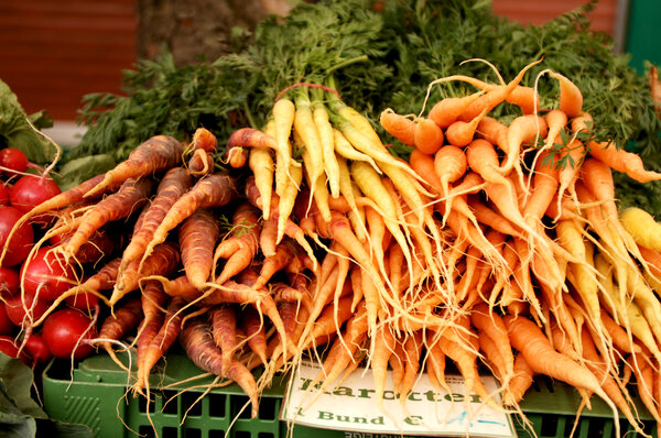 Esposto di carote vibranti a un banco del mercato, mostrando diverse varietà. | © Graz Tourismus - icegirl