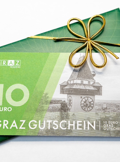 Ein Graz Gutschein im Wert von 10 Euro, dekoriert mit einer goldenen Schleife. | © Graz Tourismus - Harry Schiffer