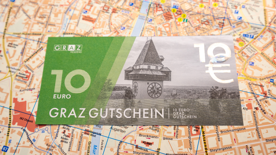 A Graz coupon worth 10 euros is placed on a map of Graz. | © Graz Tourismus - Harry Schiffer