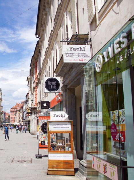 View of a busy street in Graz with shops and tram. | © sFachl