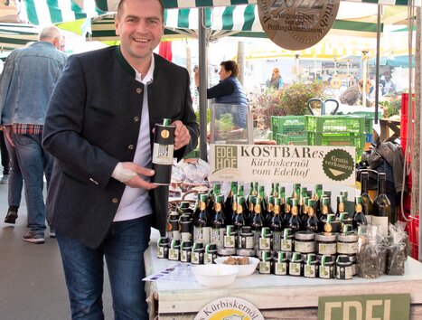 Mann verkauft Kürbiskernöl am Markt in Graz. | © Edelhof