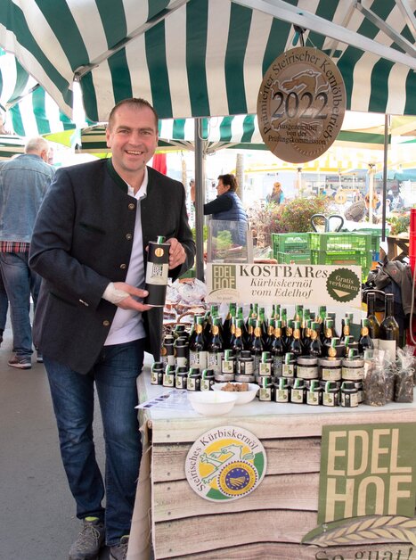 Mann verkauft Kürbiskernöl am Markt in Graz. | © Edelhof