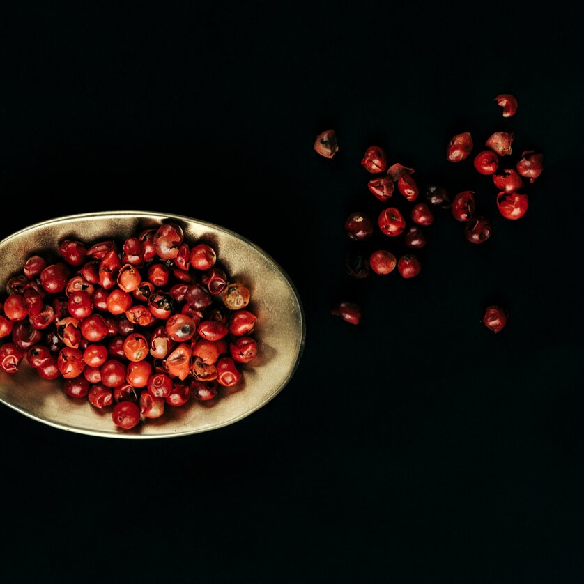 Ein Löffel mit roten Pfefferkörnern auf schwarzem Hintergrund. | © Lupi Spuma