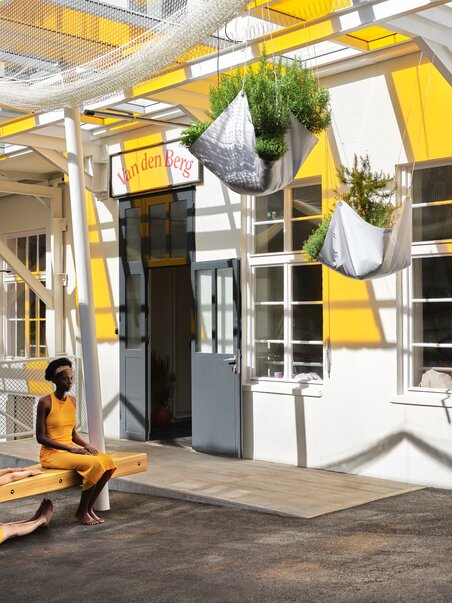 Two people in yellow clothing in front of the Van den Berg spice shop in Graz. | © Stefan Leiner