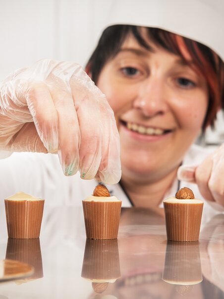 Donna che decora cioccolatini presso Eckhards Confiserie. | © Eckhards Confiserie I Graz