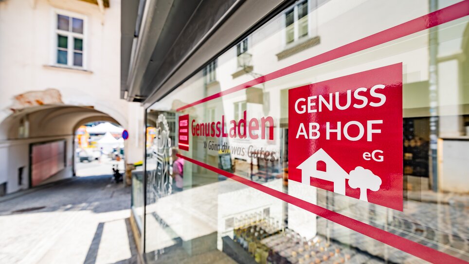 Finestra di un negozio con la scritta "GenussLaden" e "Genuss ab Hof" a Graz. | © Gut Schlossberg