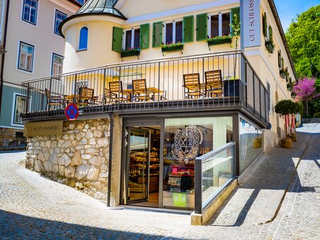 Ansicht des Geschäfts "Gut Schlossberg" in Graz - ein schönes Gebäude mit Terrasse und grünen Fensterläden. | © Gut Schlossberg
