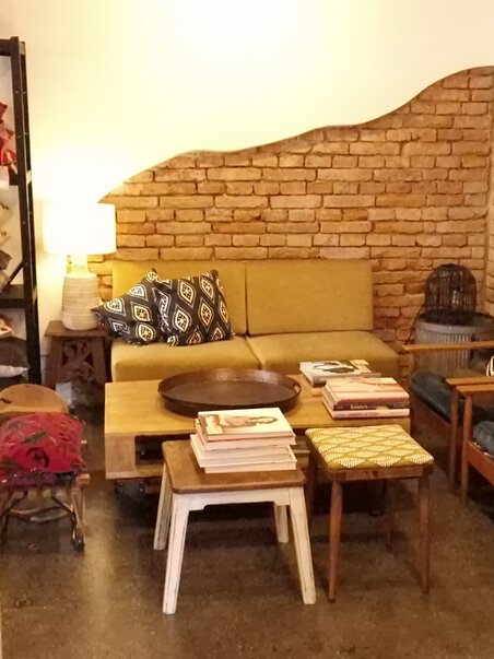 Cozy setup with wooden shelves, sofas, and decor in a lifestyle store. | © Bohemian Soul Beehive